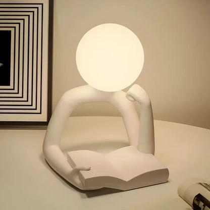 Lampada da tavolo artistica a forma di figura di lettore in resina